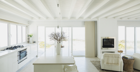 Weiße Küche mit Holzbalkendecken in einem Musterhaus, lizenzfreies Stockfoto