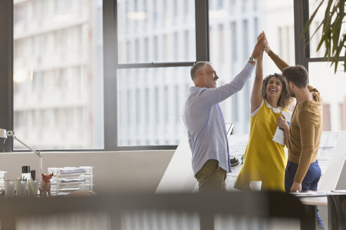 Architects high fiving in office - HOXF01009