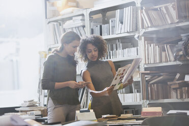 Designerinnen besprechen Papierkram im Büro - HOXF01021