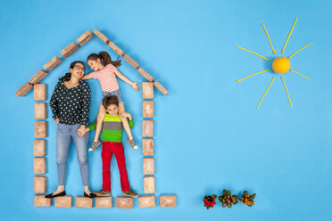 Mutter und Kinder stehen in ihrem Haus mit einem schönen Garten - BAEF01564