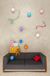 Luftballons und Luftschlangen mit Geschenken auf einer Couch - BAEF01580