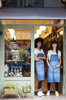 Porträt von zwei lächelnden Frauen, die in der Eingangstür eines Geschäfts stehen - EBSF02228