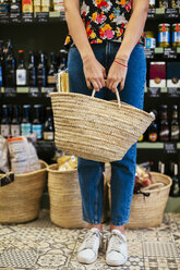 Low section of customer holding basket in a store - EBSF02265