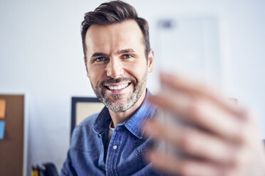 Glücklicher Mann im Büro, der ein Selfie macht - BSZF00274