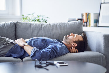 Relaxed man sleeping on sofa - BSZF00296