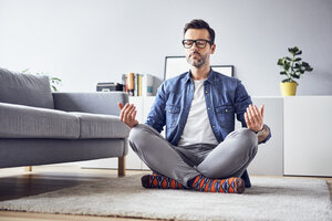 Entspannter Mann meditiert zu Hause - BSZF00303