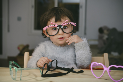 Portrait of baby girl playing with toy glasses stock photo