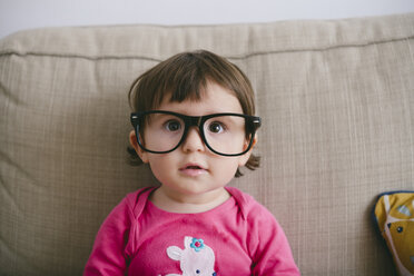 Portrait of staring baby girl wearing oversized glasses - GEMF01899