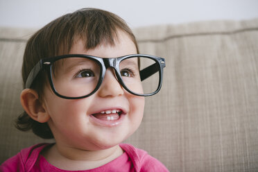 Portrait of laughing baby girl wearing oversized glasses - GEMF01900