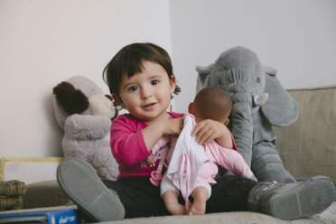 Portrait of smiling baby girl playing with doll at home - GEMF01901