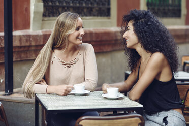 Two friends drinking coffee in sidewalk cafe - JSMF00048