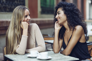 Two friends talking together in sidewalk cafe - JSMF00051