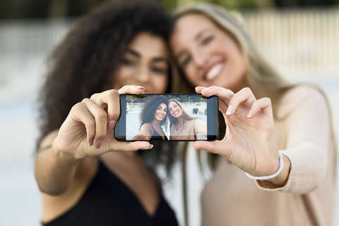 Zwei Freunde machen ein Selfie mit Handy, Nahaufnahme, lizenzfreies Stockfoto