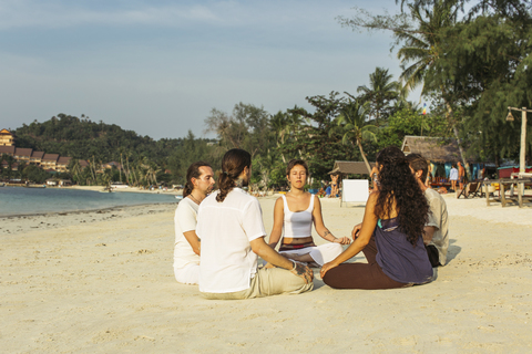 Thailand, Koh Phangan, group of people meditating together on a beach stock photo