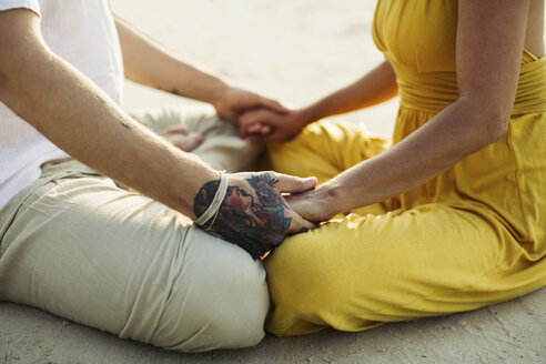 Close-up of tattooed man holding hands of woman - MOMF00396