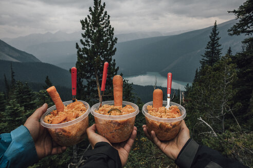Canada, British Columbia, Yoho National Park, hikers holding rice dishes in plastic bowls - GUSF00335