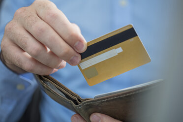 Man's hands holding credit card and purse, close-up - ZEF15109