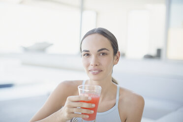 Portrait confident brunette woman drinking juice - HOXF01026