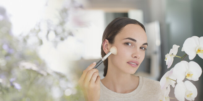 Brünette Frau trägt Make-up mit Puderpinsel auf - HOXF01034