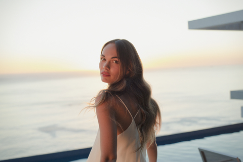 Porträt ernst, schöne Frau auf Luxus-Terrasse mit Blick auf den Sonnenuntergang Meer, lizenzfreies Stockfoto