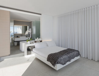 Bed in modern, luxury home showcase interior bedroom with en suite bathroom - HOXF01070