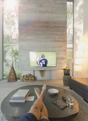 Persönliche Perspektive Mann schaut Fußball im Fernsehen im Wohnzimmer - HOXF01093