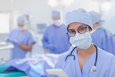 Porträt einer selbstbewussten Chirurgin mit chirurgischer Maske im Operationssaal - HOXF01113