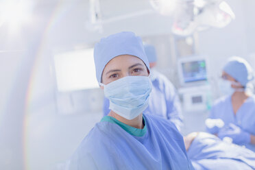 Portrait confident female surgeon wearing surgical mask in operating room - HOXF01117