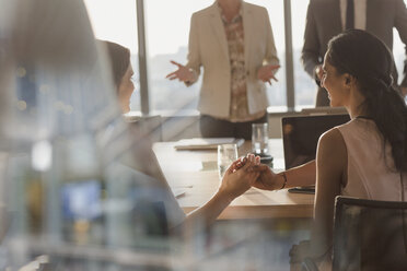 Businesswomen shaking hands in conference room meeting - HOXF01134