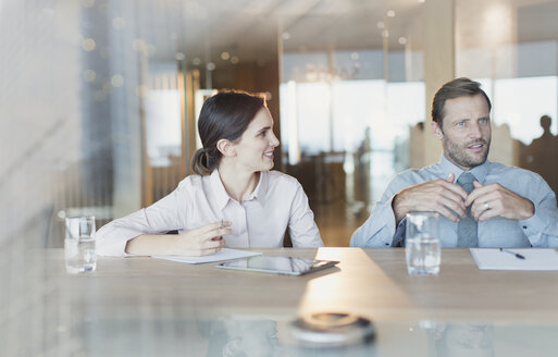 Geschäftsfrau hört einem Geschäftsmann in einem Konferenzraum zu - HOXF01138