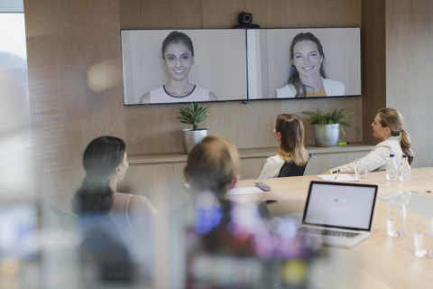 Geschäftsleute, die in einer Videokonferenz über Monitore sprechen, lizenzfreies Stockfoto