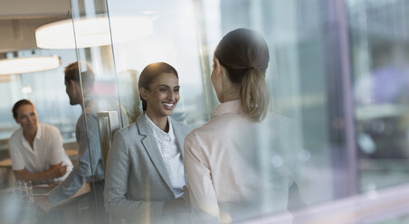 Lächelnde Geschäftsfrauen im Gespräch im Büro - HOXF01157