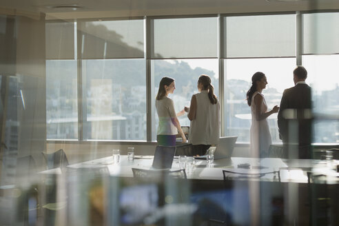Geschäftsleute im Gespräch am sonnigen Fenster im Konferenzraum Sitzung - HOXF01203