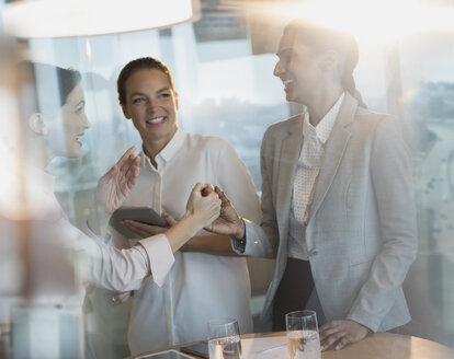 Geschäftsfrauen lachen, schütteln sich die Hände bei einer Bürobesprechung - HOXF01213