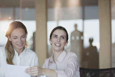 Smiling, enthusiastic businesswoman in conference room meeting - HOXF01219