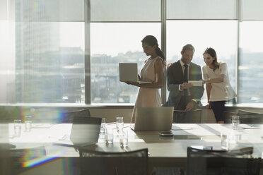 Business people working, using laptop and digital tablet in sunny conference room meeting - HOXF01223