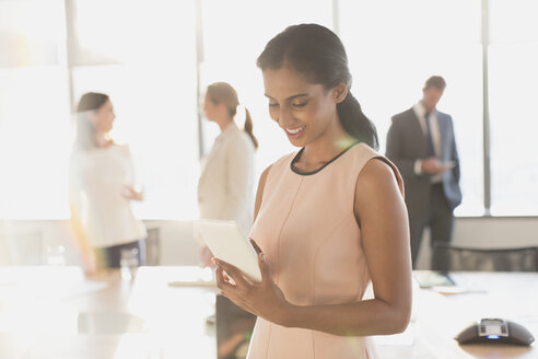 Geschäftsfrau mit digitalem Tablet im sonnigen Konferenzraum - HOXF01226