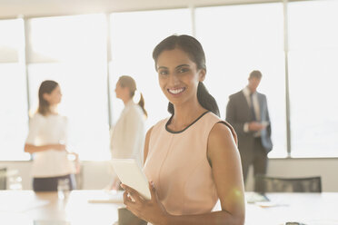 Portrait smiling, confident businesswoman with digital tablet in conference room - HOXF01238