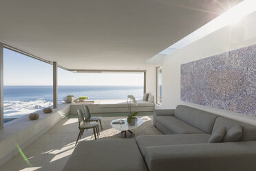 Sunny modern, luxury home showcase interior living room with ocean view - HOXF01269