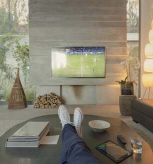 Persönliche Perspektive Frau schaut Fußball im Fernsehen im Wohnzimmer - HOXF01311