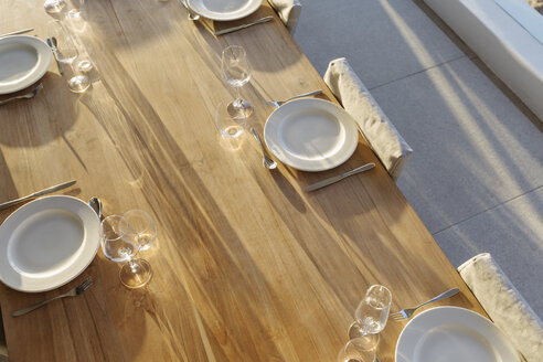 Placesettings on sunny wooden patio table - HOXF01333