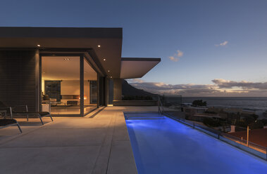 Tranquil blauen Runde Schwimmbad außerhalb der modernen Luxus-Haus Schaufenster außen in der Abenddämmerung - HOXF01338