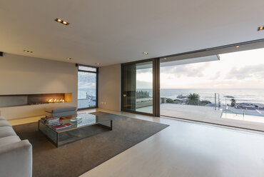 Modernes, minimalistisches Luxus-Wohnzimmer mit Gaskamin und Terrassentüren zum Meer und zur Terrasse - HOXF01342