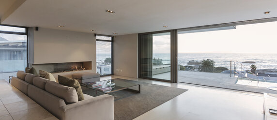 Modernes Luxus-Wohnzimmer mit Terrassentüren zum Meer und zur Terrasse - HOXF01345