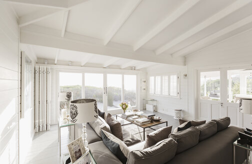 Sonniges Luxus-Wohnzimmer mit gewölbter Decke aus weißen Holzbalken - HOXF01370