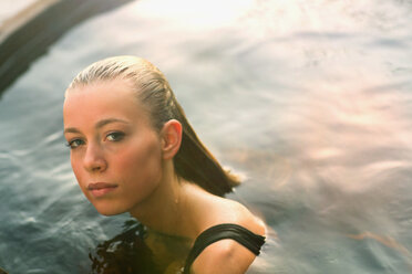 Portrait ernstes, selbstbewusstes Teenager-Mädchen im Schwimmbad - HOXF01375