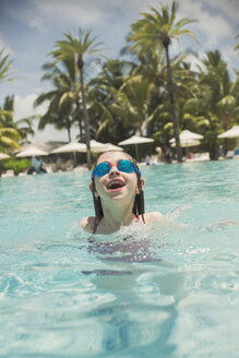 Porträt verspieltes Mädchen schwimmen mit Schwimmbrille in sonnigen tropischen Ozean - HOXF01395