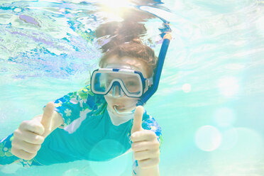 Portrait confident girl snorkeling underwater, gesturing thumbs-up - HOXF01401