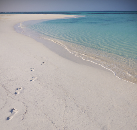 Fußabdrücke im Sand am tropischen Strand, lizenzfreies Stockfoto