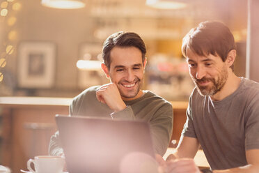 Men friends using laptop and drinking coffee in cafe - HOXF01468